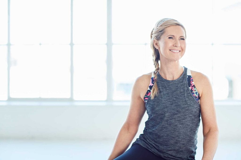 Rachel Grunwell smiling while doing Yoga
